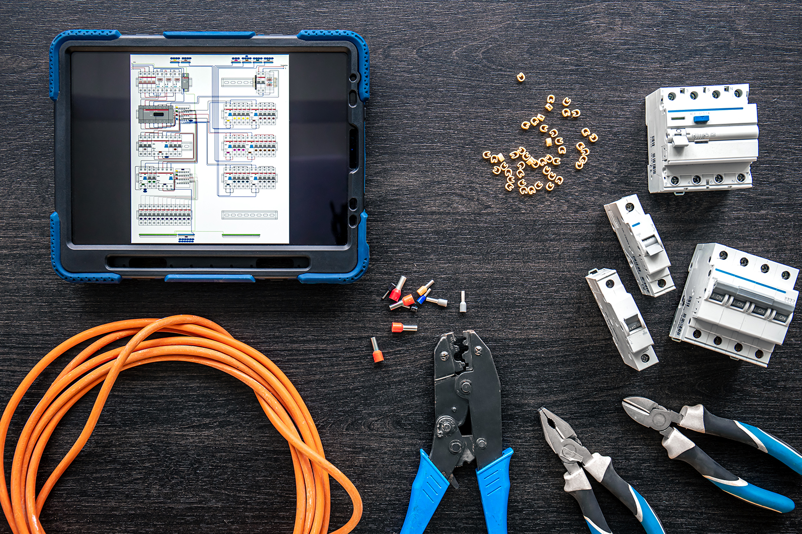 different electrical tools and digital tablet on wooden background, flat lay.