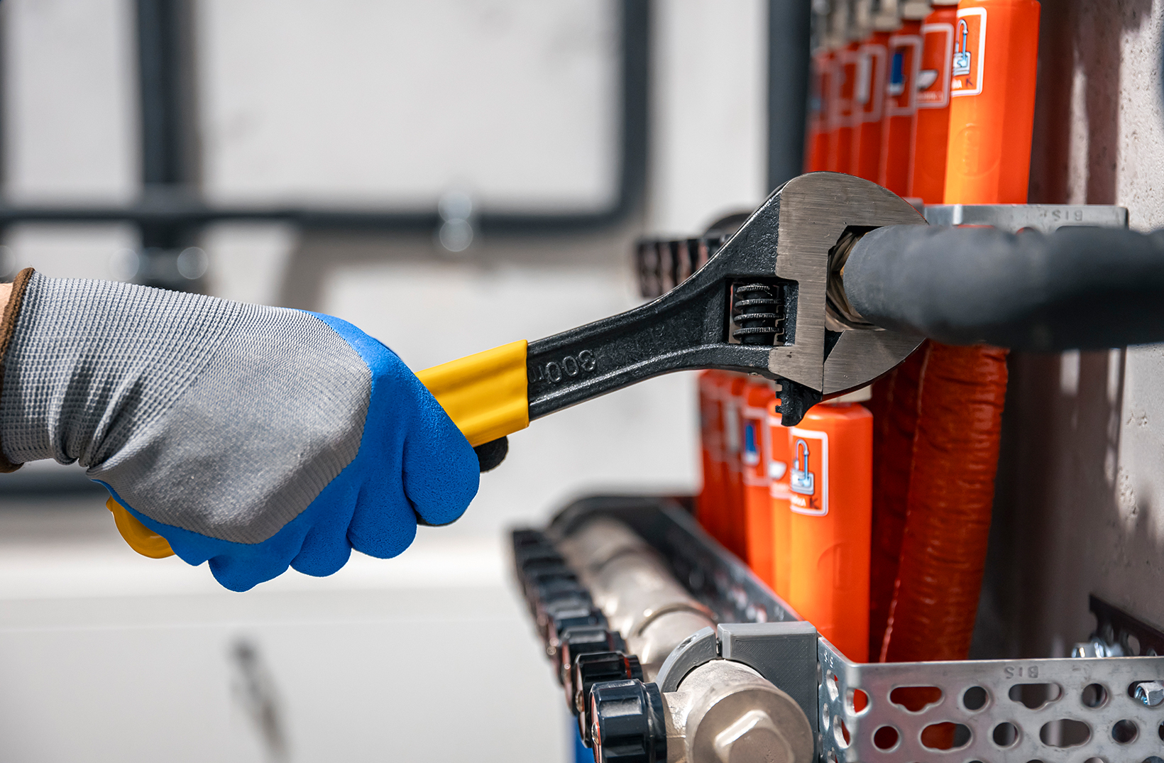 male hands with a wrench turning off valves.